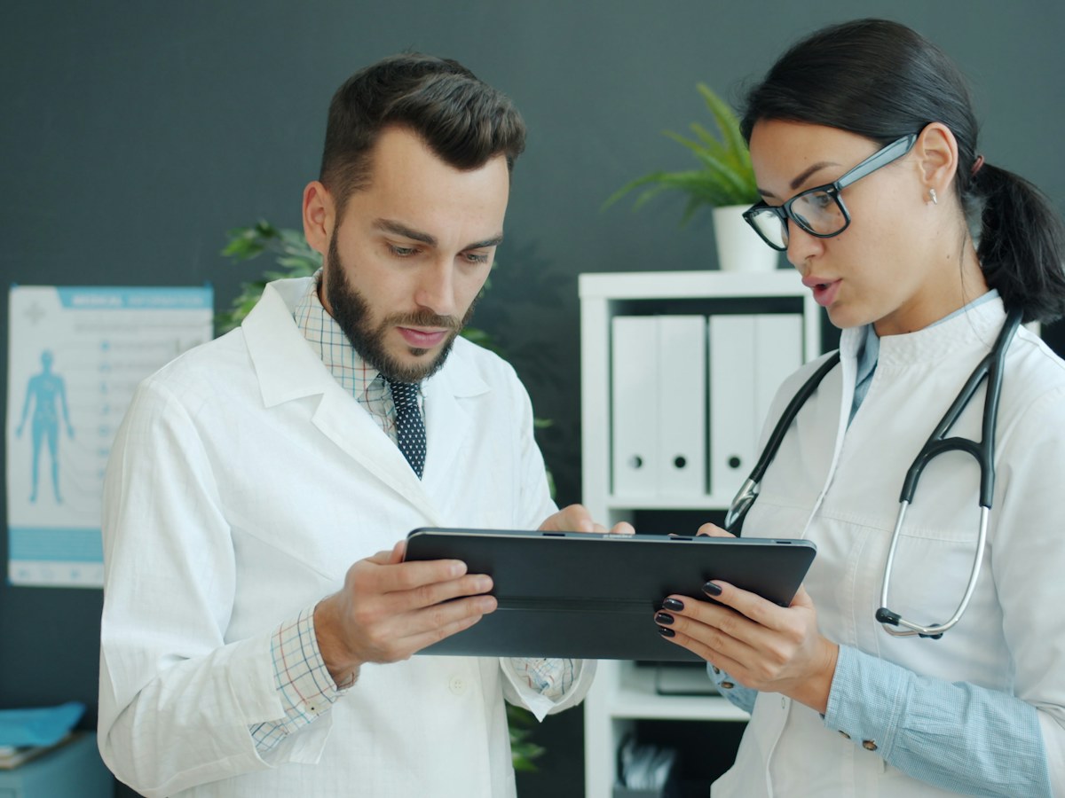 Two doctors reviewing information on a tablet together