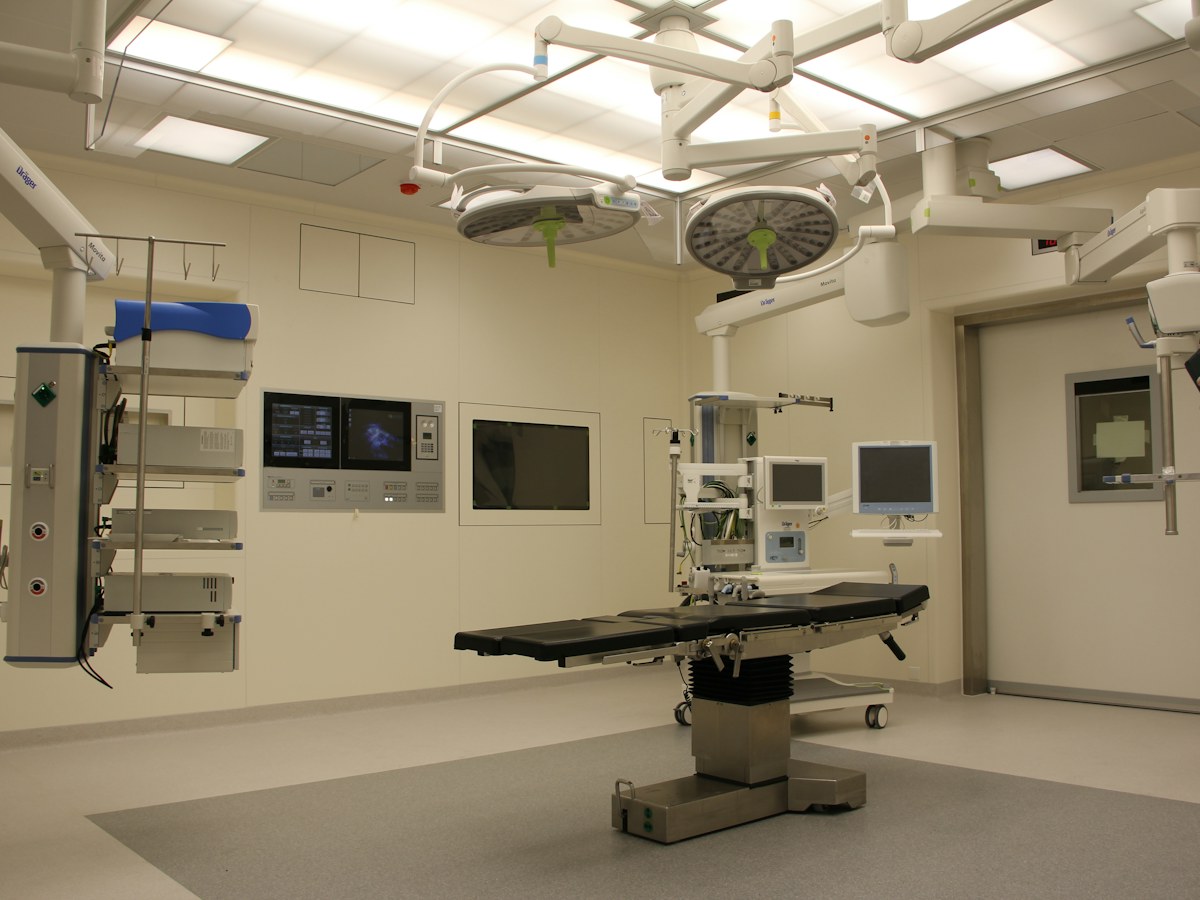 Hospital operating room with surgical table, overhead lights and medical equipment