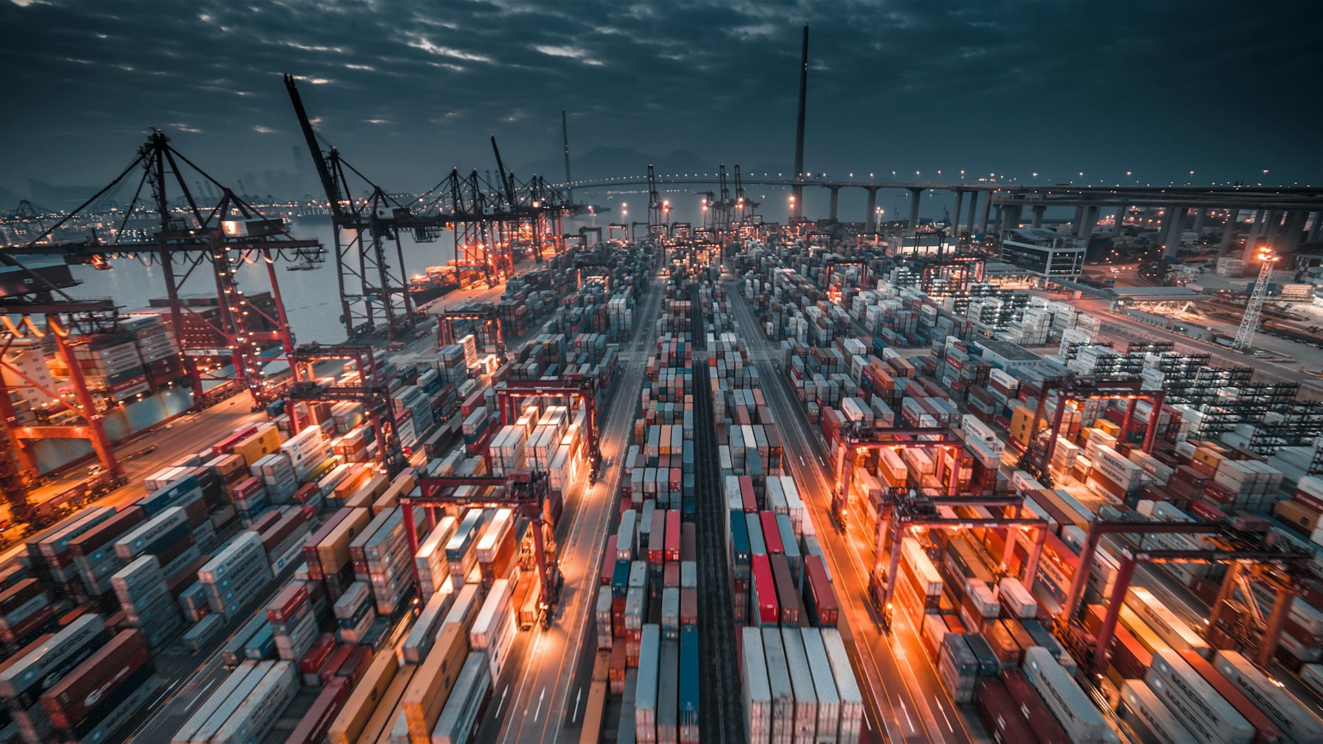 Busy shipping terminal with stacked containers and gantry cranes