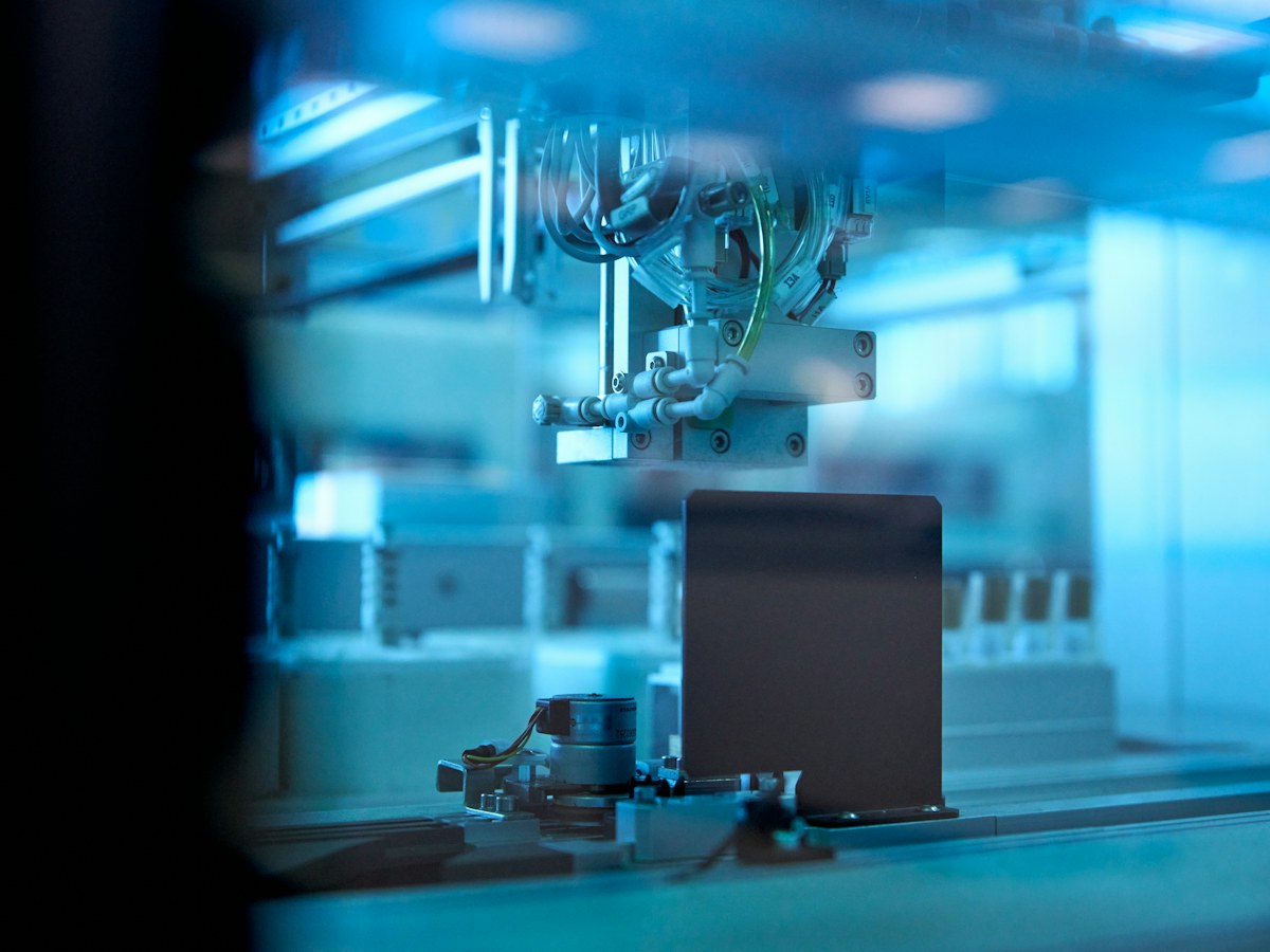 Industrial robotic arm working in a blue-lit automated facility