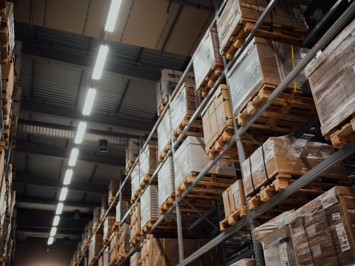 Cardboard cartons stored on white metal warehouse racking